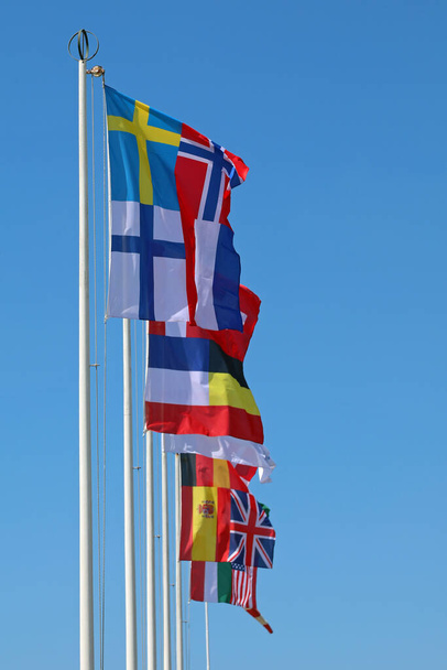 mezinárodních vlajek na tyči vlnící se během setkání zástupců různých národů - Fotografie, Obrázek