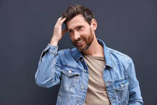 Portrait of smiling handsome bearded man on grey background - Photo, image