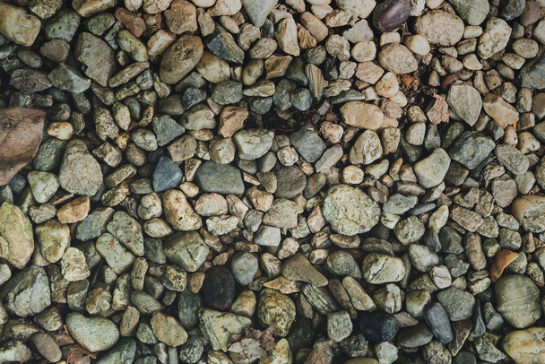 Pohled shora hladké kulaté oblázkové kameny abstraktní textury pozadí. Dovolená rekreace na pláži koncept. Koncept oblázkové textury přírodního kamene. - Fotografie, Obrázek