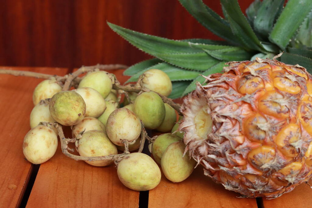 クローズアップ写真に熟した果物のコレクション。木の背景に熟したパイナップルと熟した果物の多く - 写真・画像