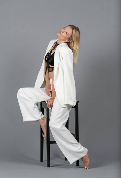 Portrait of Blonde Woman With White Jacket and Trousers. Isolated on Gray Background. Happy Face of Caucasian White Woman - Φωτογραφία, εικόνα