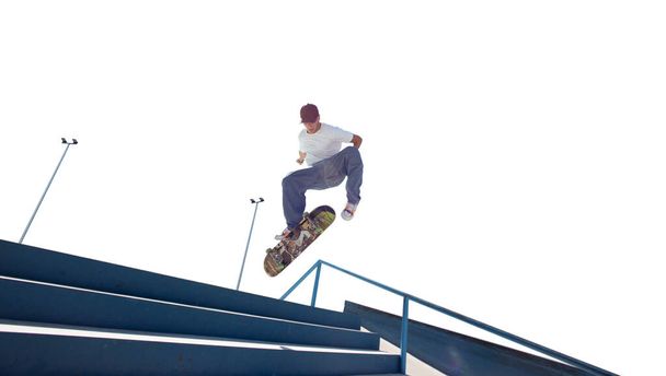 Skateboarder doet een truc geïsoleerd op witte achtergrond - Foto, afbeelding