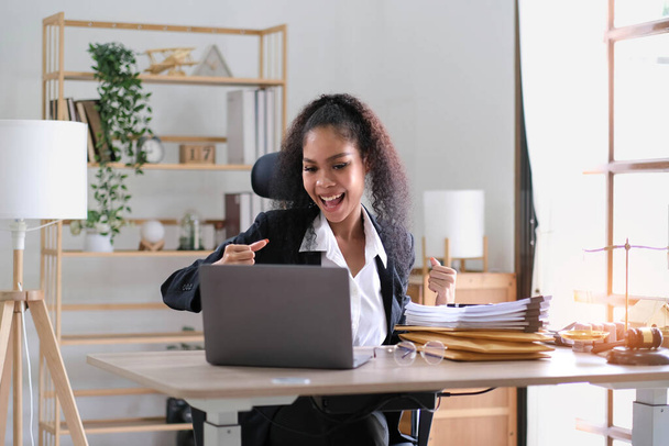 Молодая успешная американская бизнесвумен поднимает руки вверх и смеется от счастья над офисом - Фото, изображение