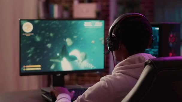 Over shoulder view of gamer feeling unhappy after losing difficult level in online space shooter on gaming pc at home. Man playing internet multiplayer game disappointed after failing competition. - Materiał filmowy, wideo
