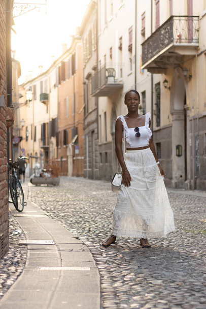 Portrait of African American woman dressed in white getting to know Europe, Ferrara. Italy. High quality photo - Fotografie, Obrázek