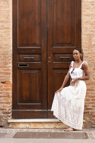 Ritratto di donna afroamericana vestita di bianco per conoscere l'Europa, Ferrara. Italia. Foto di alta qualità - Foto, immagini