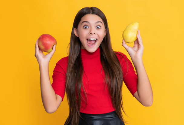 smiling amazed child with fresh apple and pear on yellow background. - Fotografie, Obrázek
