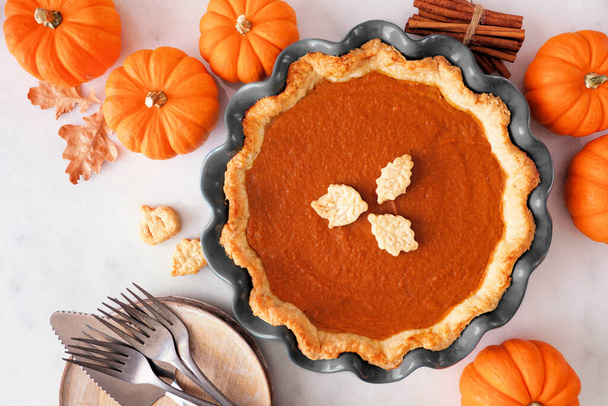 Homemade autumn pumpkin pie. Top view table scene on a white marble background. - Photo, Image