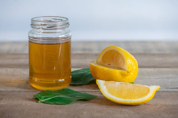 Honig und Zitrone auf einem Holztisch. - Foto, Bild
