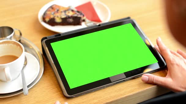 Γυναίκα που εργάζεται στην οθόνη του tablet πράσινο σε καφέ - καφέ και κέικ - Πλάνα, βίντεο