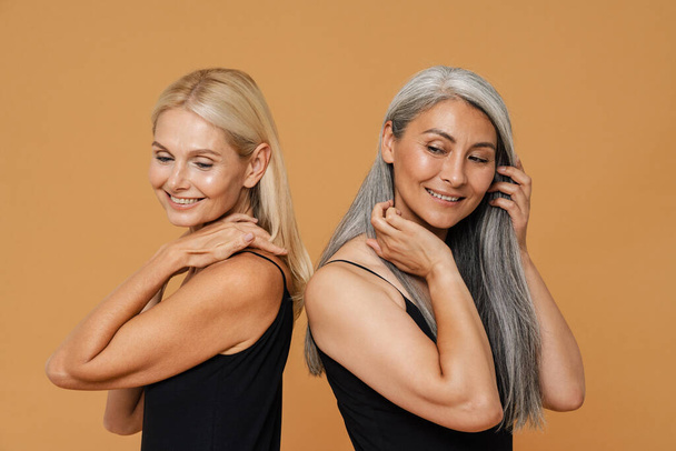 Mature multiracial beautiful women wearing bodysuits smiling and posing isolated over yellow background - Φωτογραφία, εικόνα