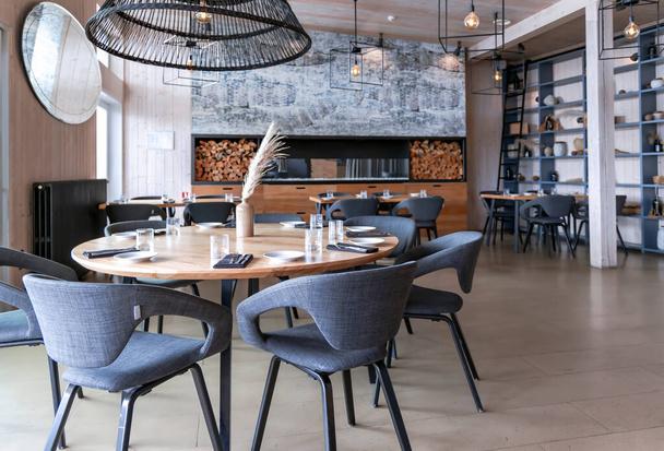 LATVIA, RIGA, AUGUST, 2022: Elegáns modern belső Aqua Luna étterem kandallóval Andrejosta negyedben a Daugava folyó partján Rigában, Lettországban Rigában, Lettország fővárosában. EU. - Fotó, kép
