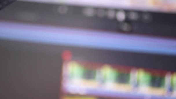 Mano masculina sosteniendo una vieja tira de película en primer plano frente a un moderno software de edición de video digital en la pantalla del monitor que muestra la innovación técnica y la evolución de los clips de cinematografía y edición de video - Metraje, vídeo