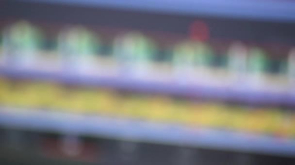 Mano masculina sosteniendo una vieja tira de película en primer plano frente a un moderno software de edición de video digital en la pantalla del monitor que muestra la innovación técnica y la evolución de los clips de cinematografía y edición de video - Metraje, vídeo
