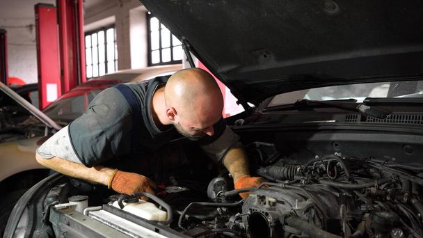 Auto mechanic repairs SUV engine. auto repair station - Photo, Image