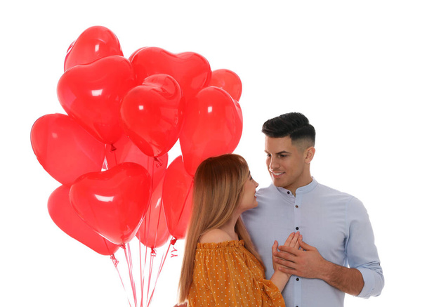 Lovely couple with heart shaped balloons on white background. Valentine's day celebration - Photo, Image