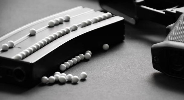 Bolas de bala de plástico branco de arma airsoft ou bb arma no chão escuro, foco suave e seletivo em pelotas brancas. - Foto, Imagem