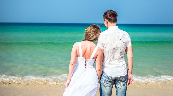 Milující pár na tropické pláži proti moři - Fotografie, Obrázek