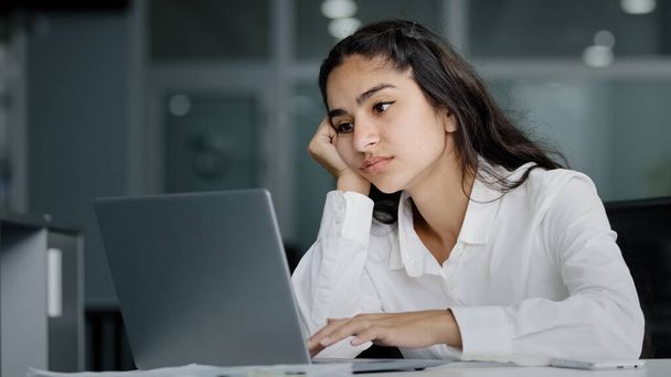Нудно сумна лінива молода індійська жінка менеджер сидить в офісі не мотивований нецікавий в нудному ноутбуці, працює над перевантаженою втомленою сонною бізнес-леді відчуває втому виснажену роботу
 - Фото, зображення