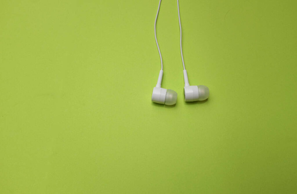 From a above white headphones,earphone,earbuds with headset on isolated green bright background - Photo, Image