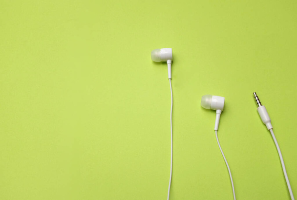 copy space white headphones,earphone,earbuds with headset on isolated green bright background - Photo, Image