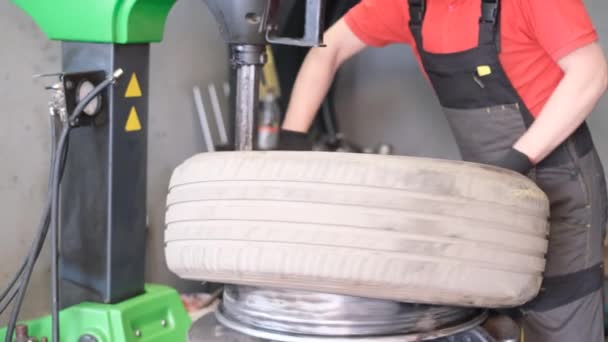 Balancing and repair of car wheels. A car mechanic works in a workshop. Car service - Footage, Video