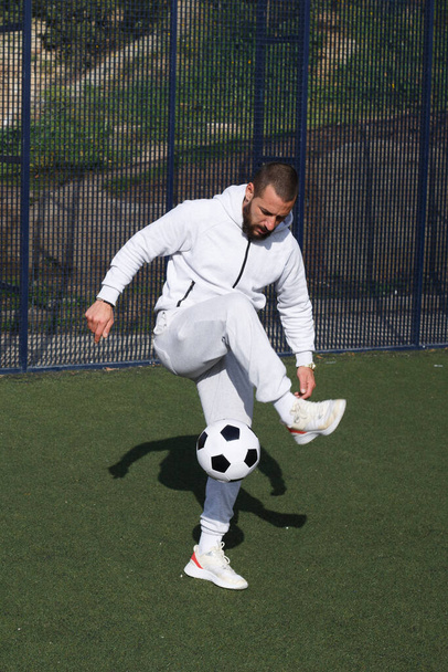 Mladý fotbalista žongluje s míčem na fotbalovém hřišti - Fotografie, Obrázek