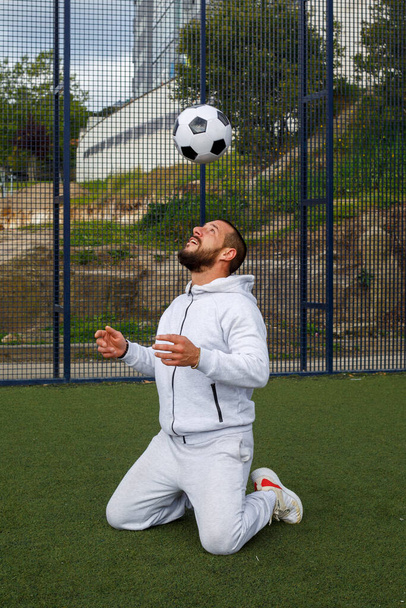 若い男性サッカー選手はサッカー場でボールをジャグリング - 写真・画像