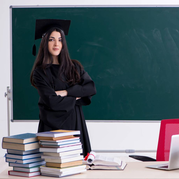 The female graduate student in front of green board - Foto, Imagen