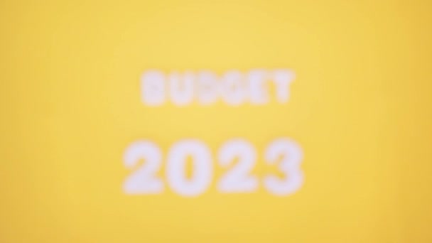 A 2023-as költségvetés fából készült számadatai sárga alapon. - Felvétel, videó