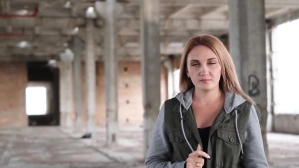Egy ukrán lány énekel a háború romjain. Az ukrajnai háború következményei. A lány a háború végéért imádkozik. Háború Ukrajnában. Egy nő egy romos épületben. - Felvétel, videó