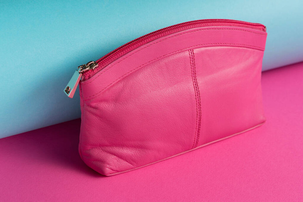Rózsaszín női kuplung vagy pénztárca található színes háttér, átlós elrendezése, közelkép - Fotó, kép