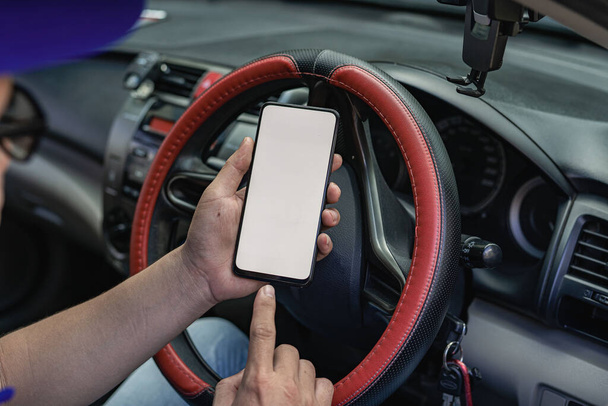 GPSで方向を見つけるために車の概念を駆動する白い画面サイズの携帯電話. - 写真・画像