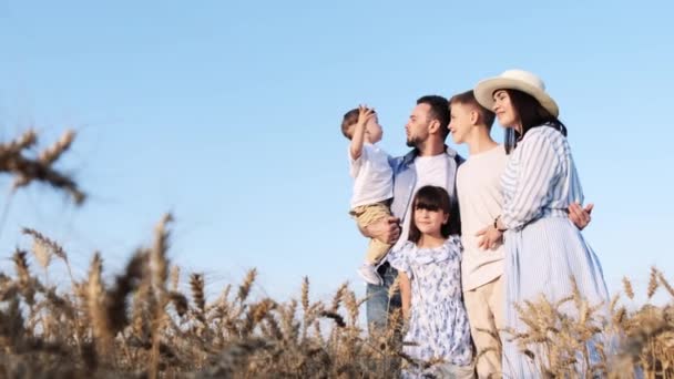 Happy family at sunset in the field. Parents and children, rest together. Love reigns in the family. Children dream in the field. The concept of a strong and happy family - Footage, Video