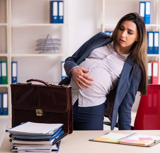 Η νεαρή έγκυος που εργάζεται στο γραφείο - Φωτογραφία, εικόνα