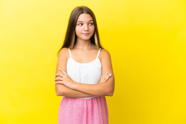 Little caucasian girl isolated on yellow background looking to the side - Photo, image