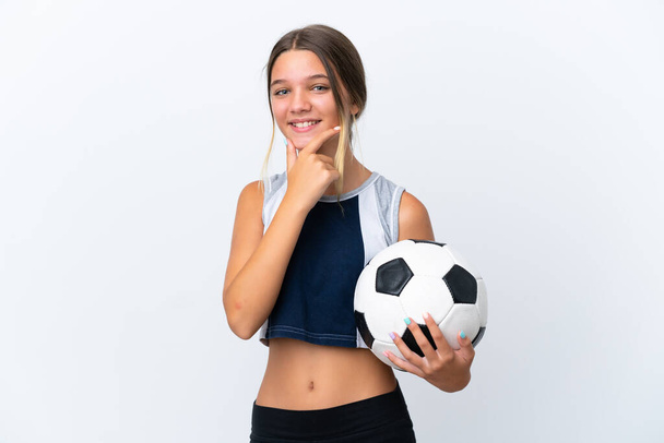 Pequeña chica caucásica jugando fútbol aislado sobre fondo blanco feliz y sonriente - Foto, Imagen
