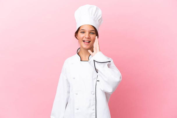 Pieni valkoihoinen kokki tyttö eristetty vaaleanpunainen tausta huutaa suu auki - Valokuva, kuva