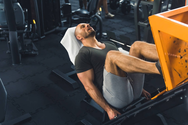 it is time for leg press exercises, a man working out at the gym. High quality photo - Foto, afbeelding