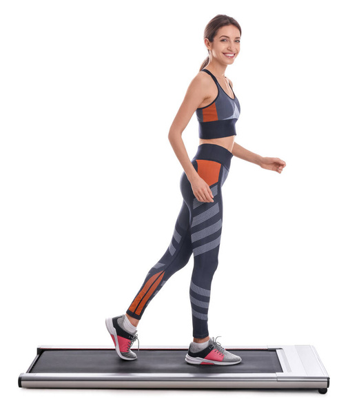 Sporty woman using walking treadmill on white background - Foto, Imagem
