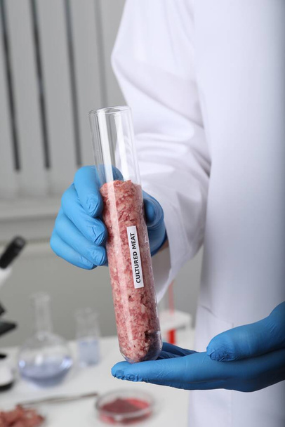 Wissenschaftler hält Reagenzglas mit rohem Hackfleisch im Labor, Nahaufnahme - Foto, Bild