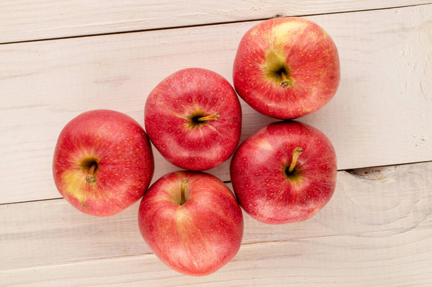 Several sweet red apples on a wooden table, macro, top view. - Photo, image