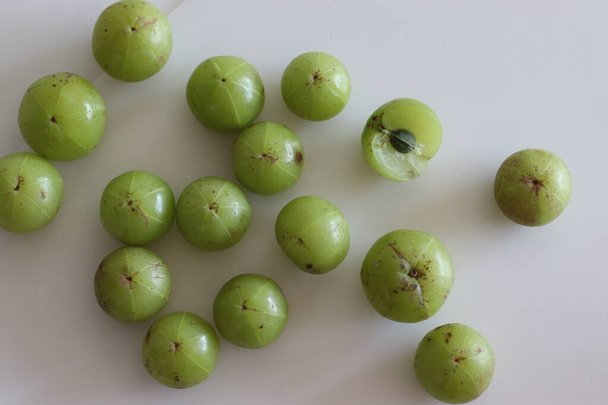 Amla or gooseberries shot on a white background. A translucent green fruit, which derives its name from the Sanskrit word Amlaki meaning nectar of life which can protect us against many ailments - Photo, Image