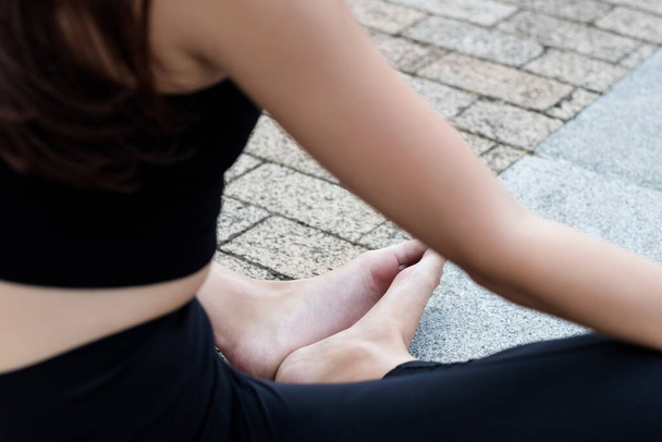 Back close-up of feet and arms of caucasian woman doing yoga on the floor. Black yoga outfit. - Foto, Bild