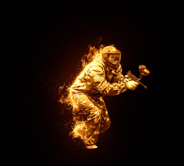 огненный пейнтбольный спортсмен в защитной форме и маске, играющий с оружием на открытом воздухе, цифровое искусство - Фото, изображение