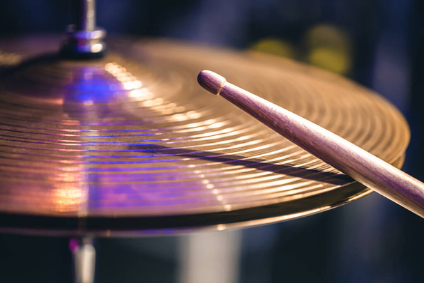 Hi-hat close-up of plates with drumsticks on a background of colored lanterns. Musical concept with a working drum. - Foto, imagen