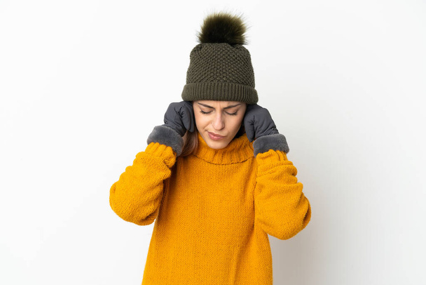 Giovane ragazza con cappello invernale isolato su sfondo bianco frustrato e coprendo le orecchie - Foto, immagini