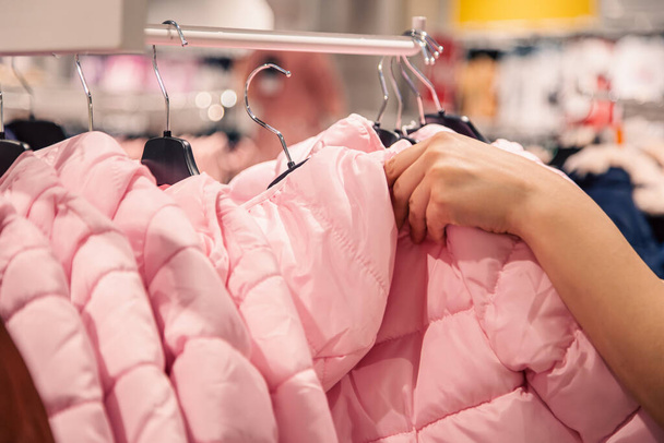 Warm childrens jackets on hangers in a clothing store., the concept of shopping for clothes for children. - Photo, Image