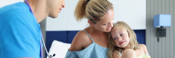 Doktor pediatr vede lékařskou konzultaci s matkou s vyděšeným dítětem. Komunikace lékařů s koncepcí dětí - Fotografie, Obrázek