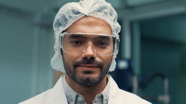 Kimyasal ve biyomedikal deneyler için tedavi laboratuvarında çalışan üniformalı bir bilim adamının portresi. - Fotoğraf, Görsel